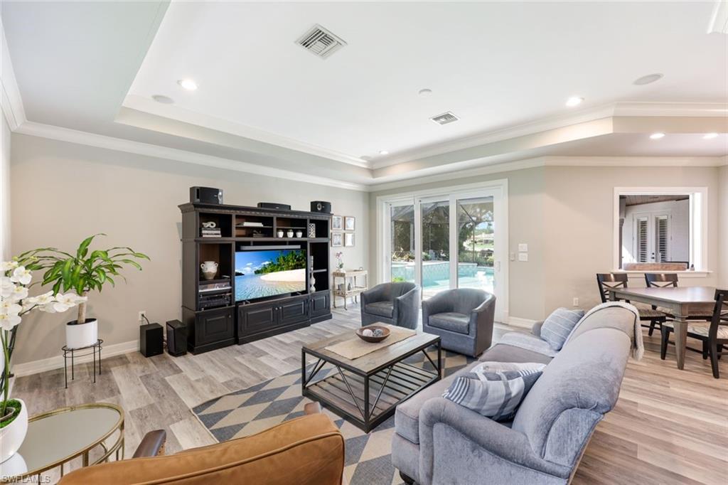 3960 Deep Passage Way Naples, FL 34109 - Photo 15 of 34 Comfortable family room with crown molding, impact glass sliders, and tray ceilings