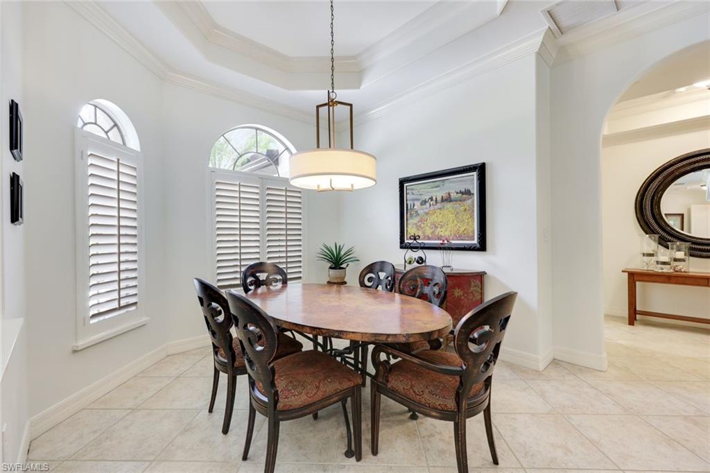 3960 Deep Passage Way Naples, FL 34109 - Photo 19 of 34 Dining room featuring decorative crown molding and a beautifully designed tray ceiling, creating a sophisticated and inviting space for memorable meals and gatherings.