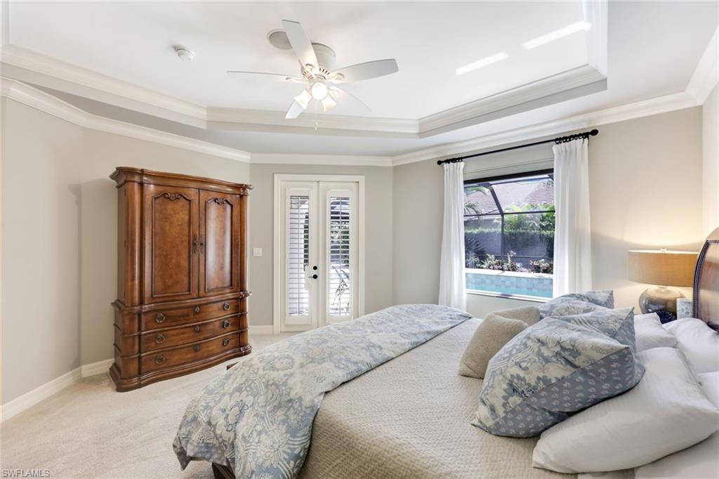 3960 Deep Passage Way Naples, FL 34109 - Photo 21 of 34 Spacious and elegant primary bedroom featuring attractive crown molding, plush carpeting on the floor, and a beautifully designed tray ceiling.