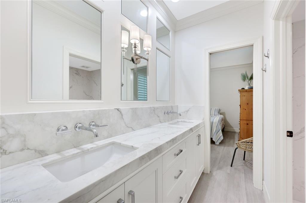 3960 Deep Passage Way Naples, FL 34109 - Photo 26 of 34 Full bath with crown molding, tasteful backsplash, double vanity, ensuite bathroom, and light wood-type flooring