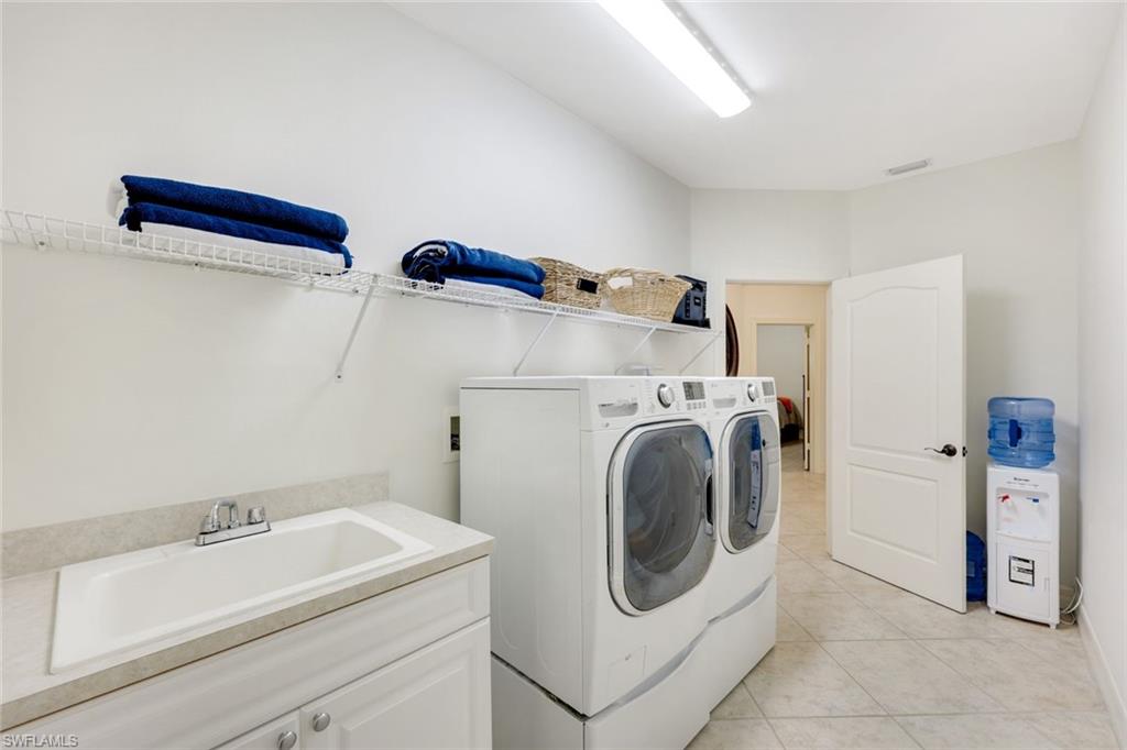 3960 Deep Passage Way Naples, FL 34109 - Photo 28 of 34 Laundry area with light tile patterned floors and washing machine and dryer
