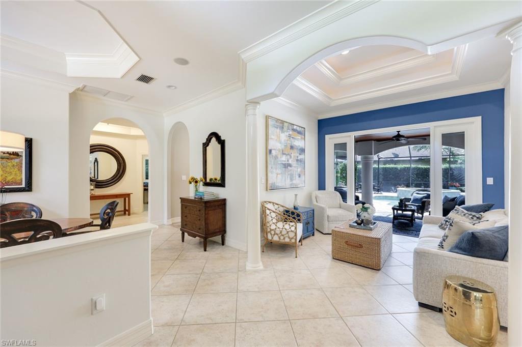3960 Deep Passage Way Naples, FL 34109 - Photo 10 of 34 Well-appointed living room featuring attractive tile flooring, tray ceilings, crown molding, and charming French doors that offer a delightful connection to the outdoors.