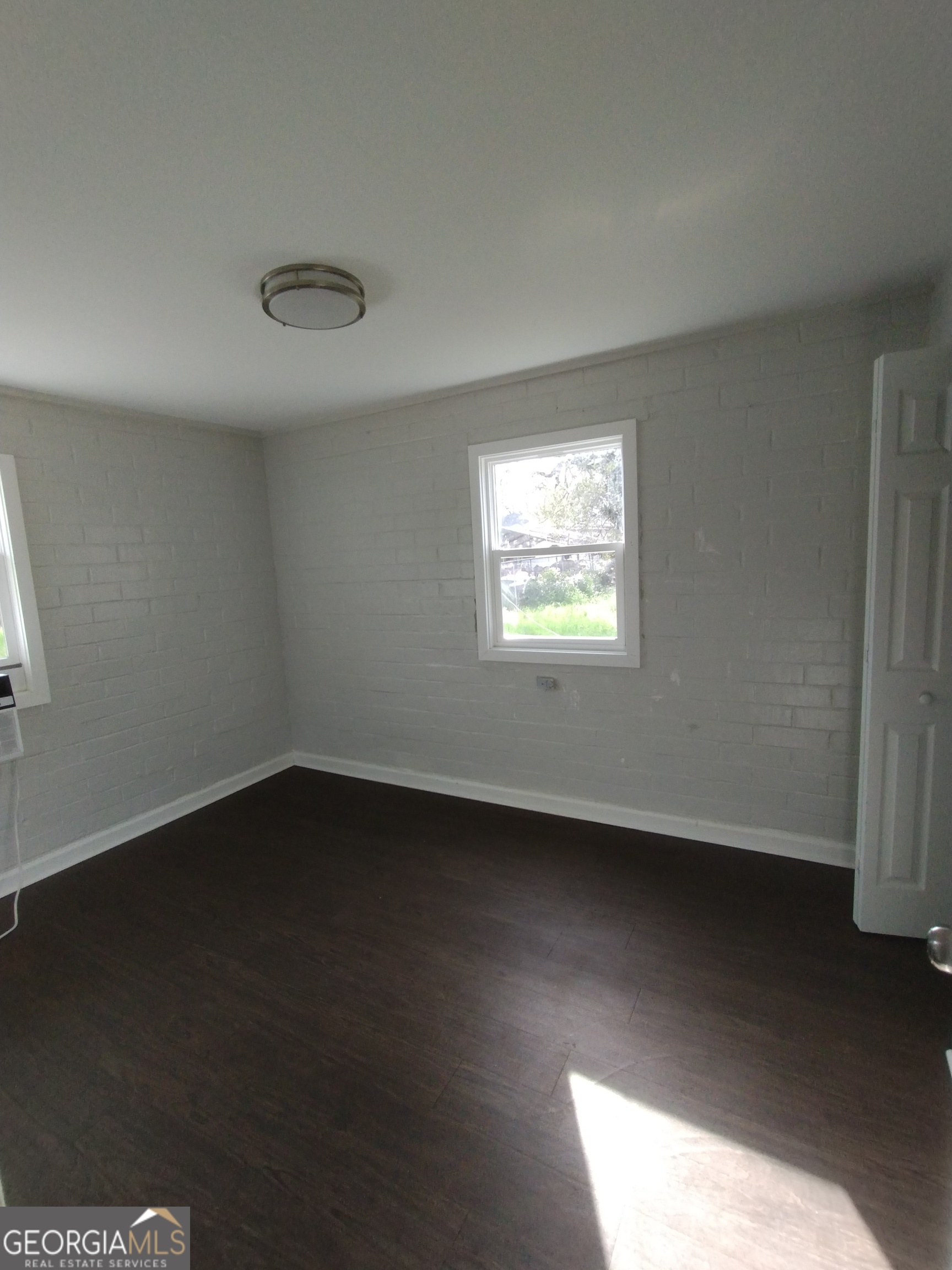 1112 Carroll Street Macon, GA 31206 - Photo 2 of 5 a view of an empty room with wooden floor and a window