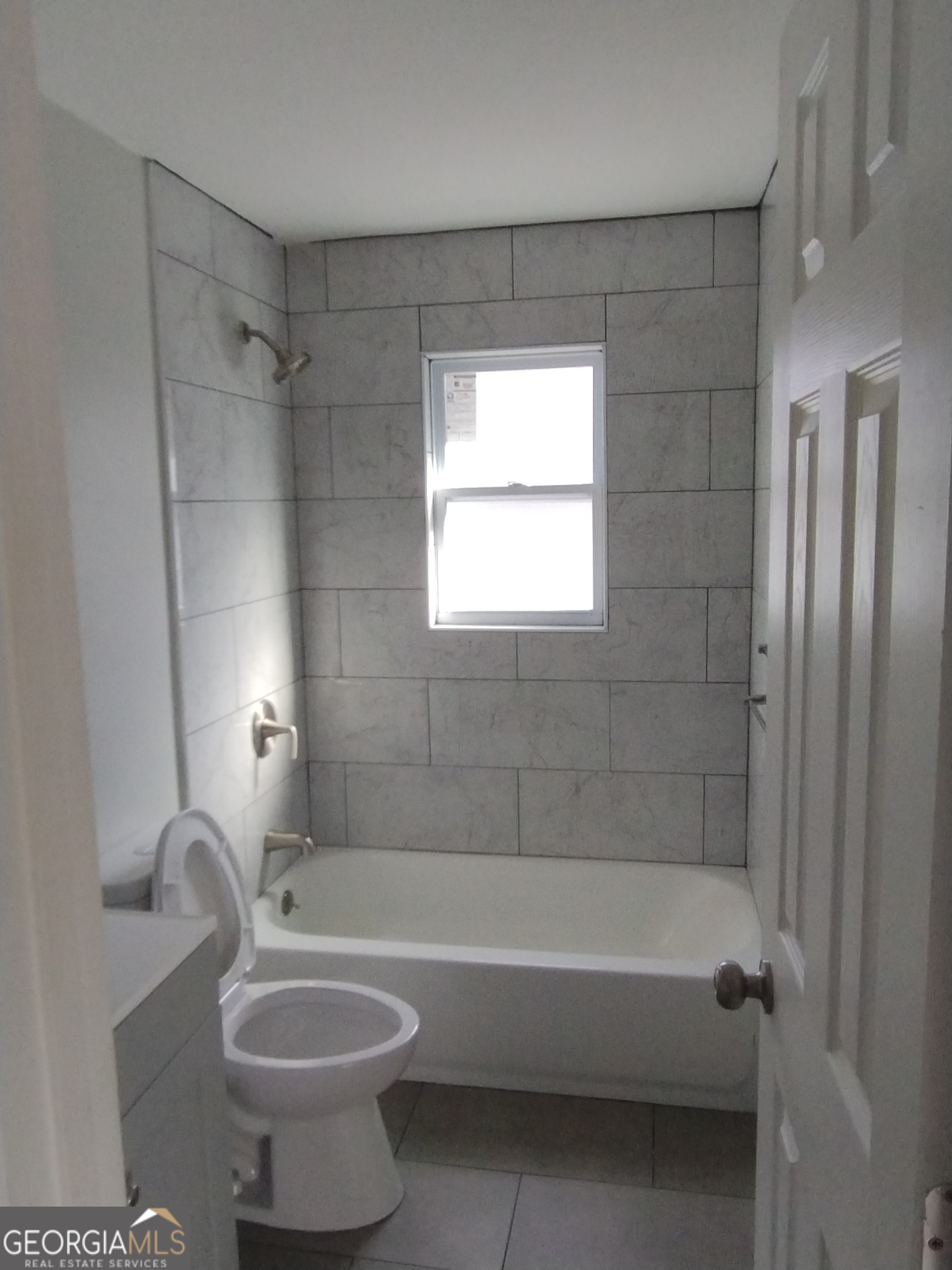 1112 Carroll Street Macon, GA 31206 - Photo 3 of 5 a bath tub sitting next to a white toilet and a shower