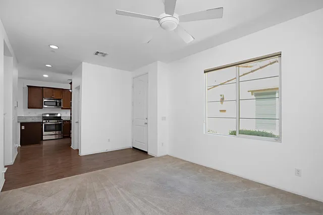 an empty room with cabinet and windows