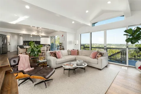 a living room with furniture floor to ceiling window and a table