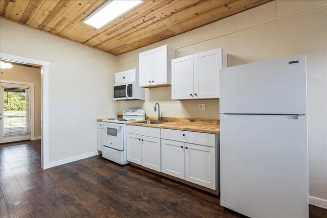 a kitchen with cabinets stainless steel appliances a sink and wooden floor