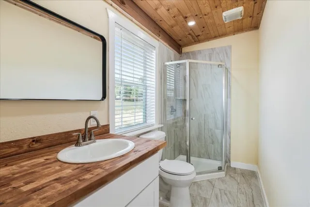 a bathroom with a sink a toilet and shower