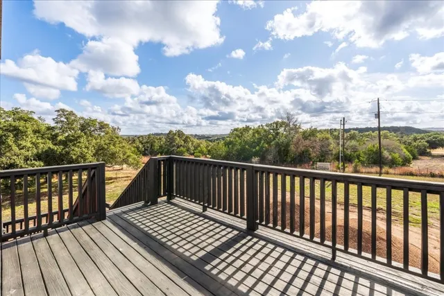a view of balcony with wooden floor & fence