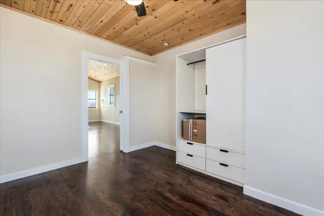 an empty room with wooden floor and cabinet
