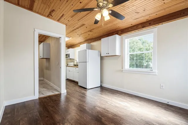 a view of a hallway with wooden floor and a chandelier