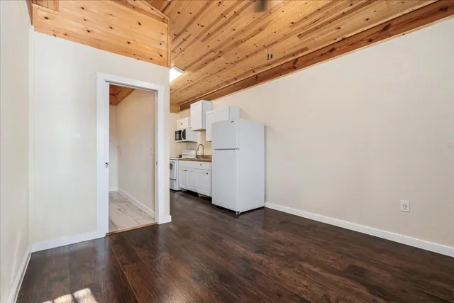 a view of a kitchen with wooden floor and electronic appliances