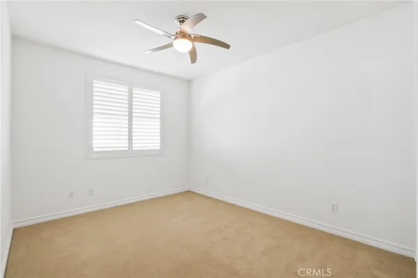 an empty room with a window and a fan