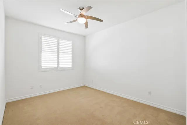 an empty room with a window and a fan