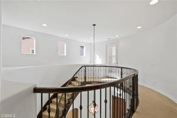 a view of staircase with railing and white walls