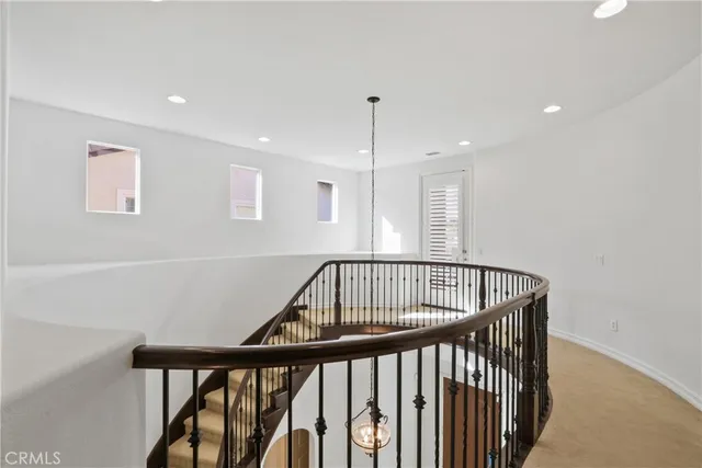 a view of staircase with railing and white walls