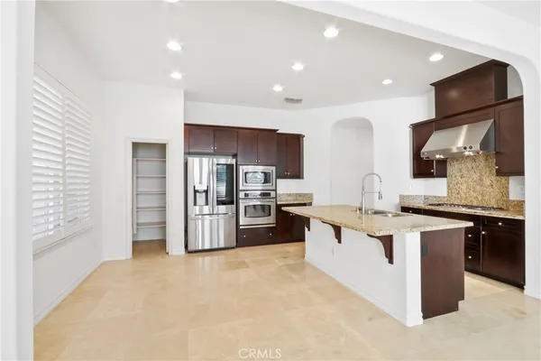 a kitchen with stainless steel appliances a sink and a refrigerator