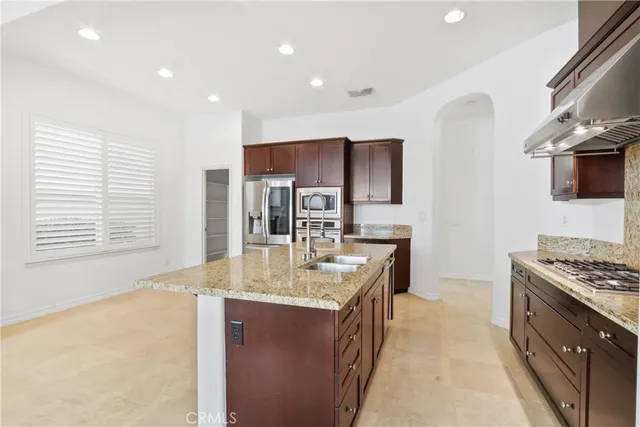 a kitchen with stainless steel appliances granite countertop a sink stove and refrigerator