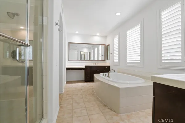 a spacious bathroom with a tub sink and mirror
