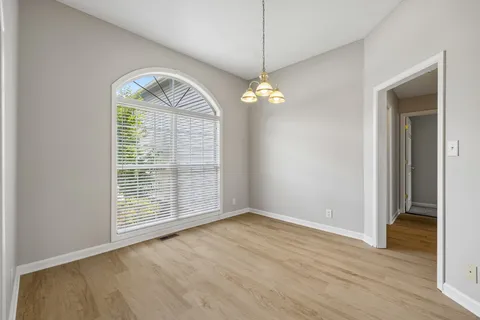 a view of a chandelier in big room and wooden floor