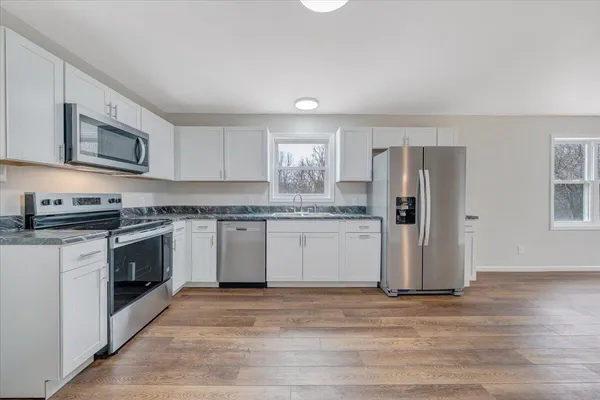 a kitchen with stainless steel appliances granite countertop a stove a sink and a refrigerator