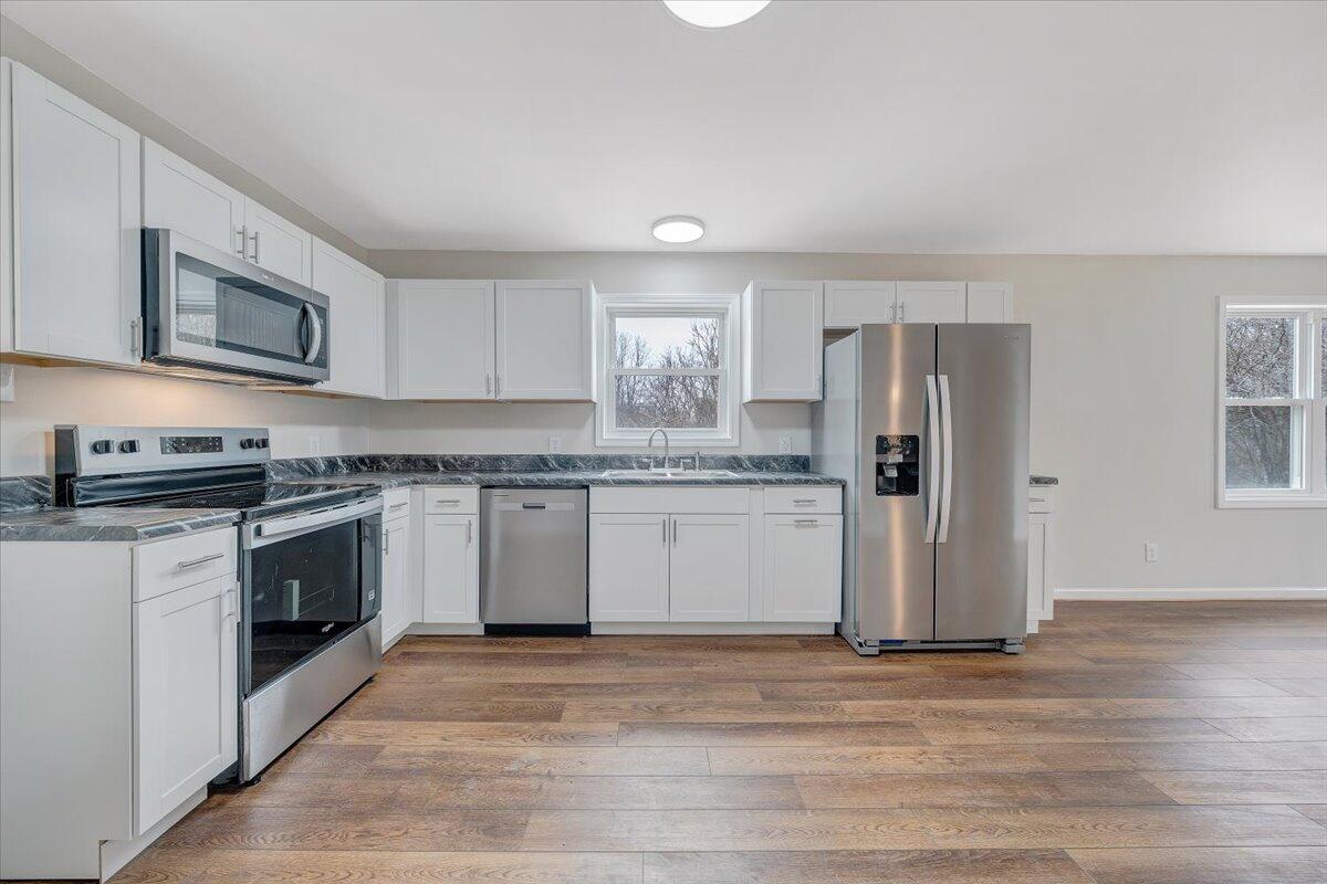 4160 Prillaman Switch Road Ferrum, VA 24088 - Photo 11 of 41 a kitchen with stainless steel appliances granite countertop a stove a sink and a refrigerator