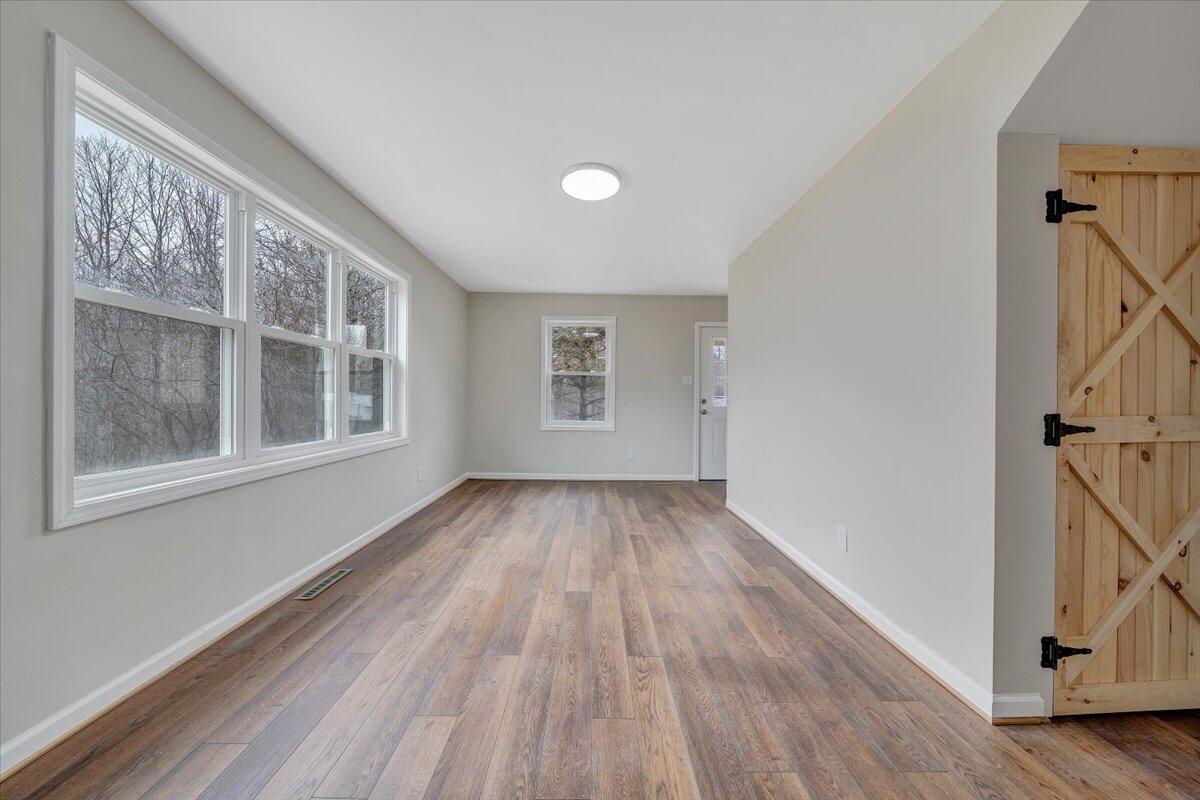 4160 Prillaman Switch Road Ferrum, VA 24088 - Photo 7 of 41 a view of an empty room with wooden floor and a window