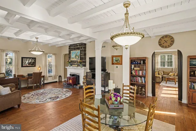 a view of a dining room with furniture a chandelier and wooden floor