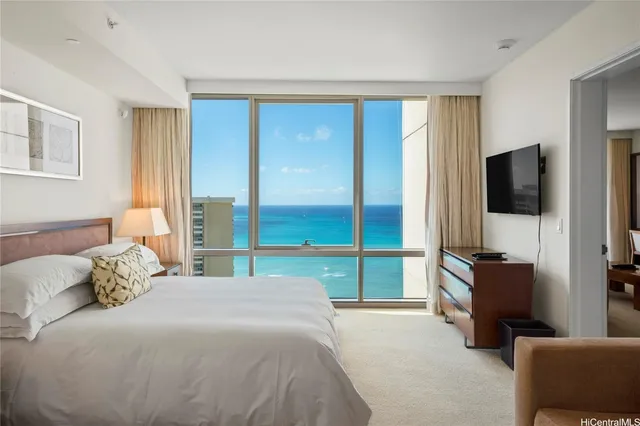 a bedroom with a bed and a flat tv screen on the dresser