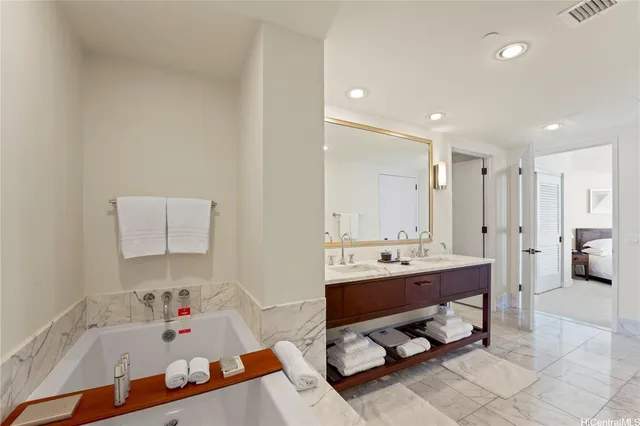 a bathroom with a tub sink and mirror