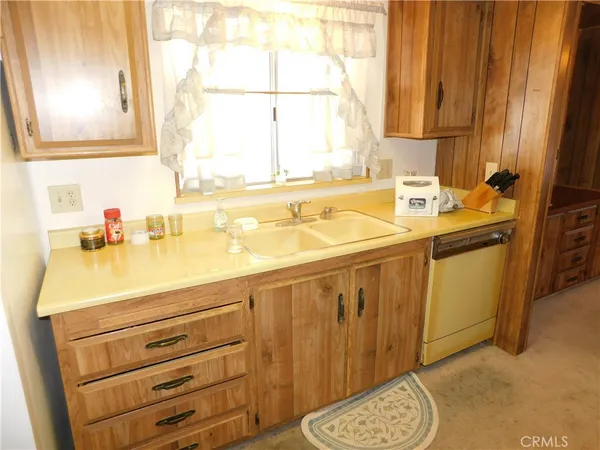 a kitchen with sink a window and cabinets