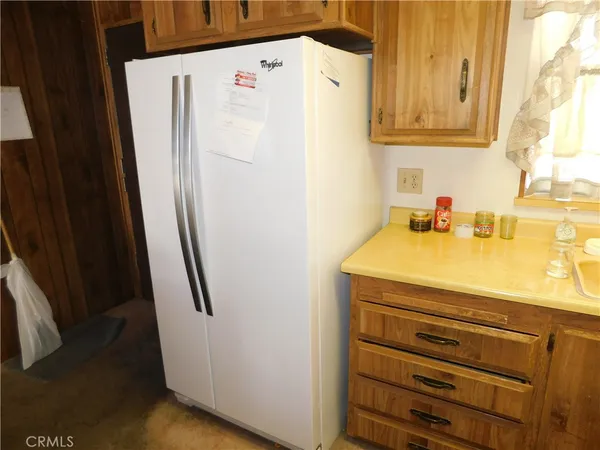 a kitchen with refrigerator and chairs