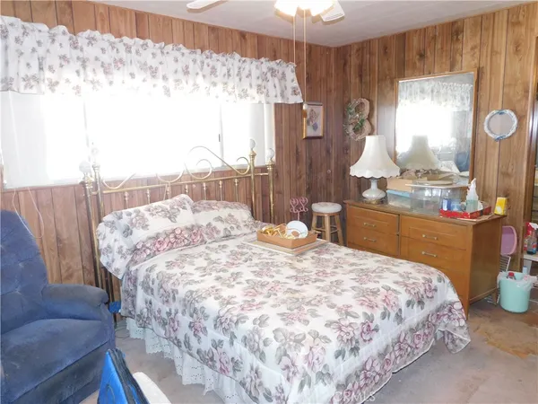 a bedroom with a bed and dresser with mirror