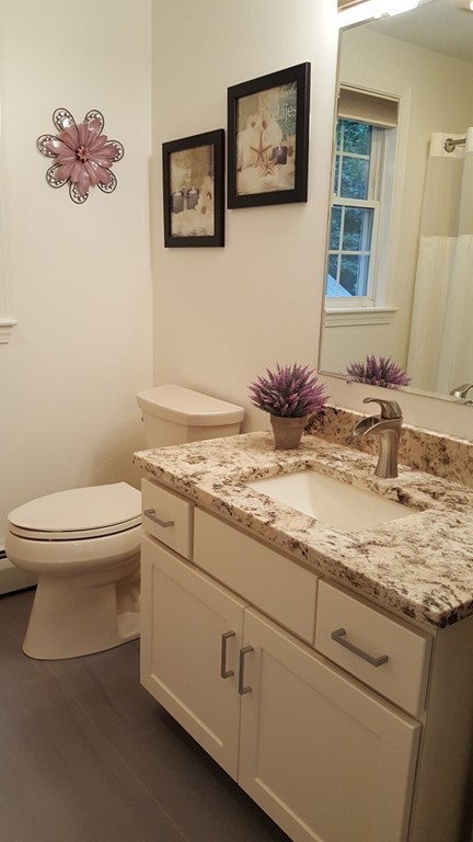 23 Calvin Street Ayer, MA 01432 - Photo 24 of 30 a bathroom with a granite countertop sink mirror vanity and toilet