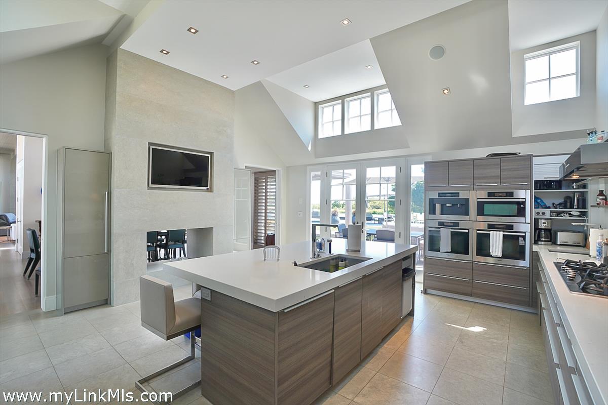 30 Crackatuxet Road Edgartown, MA 02539 - Photo 13 of 45 a living room with stainless steel appliances kitchen island granite countertop a refrigerator a stove top oven a dining table and chairs with wooden floor