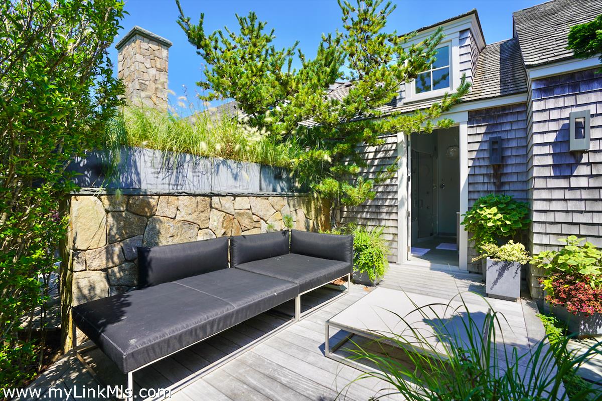 30 Crackatuxet Road Edgartown, MA 02539 - Photo 17 of 45 a view of a patio with couches and a potted plant on a wooden floor