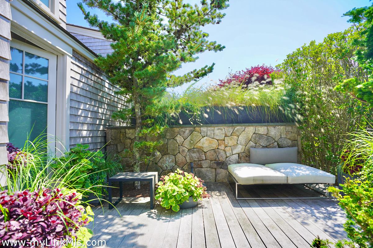 30 Crackatuxet Road Edgartown, MA 02539 - Photo 23 of 45 a backyard of a house with lots of green space and a fountain