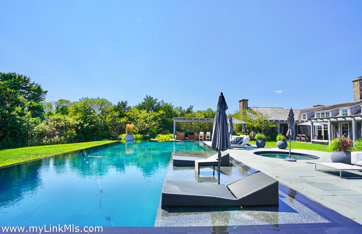 30 Crackatuxet Road Edgartown, MA 02539 - Photo 3 of 45 a view of a lake with couches and wooden floor