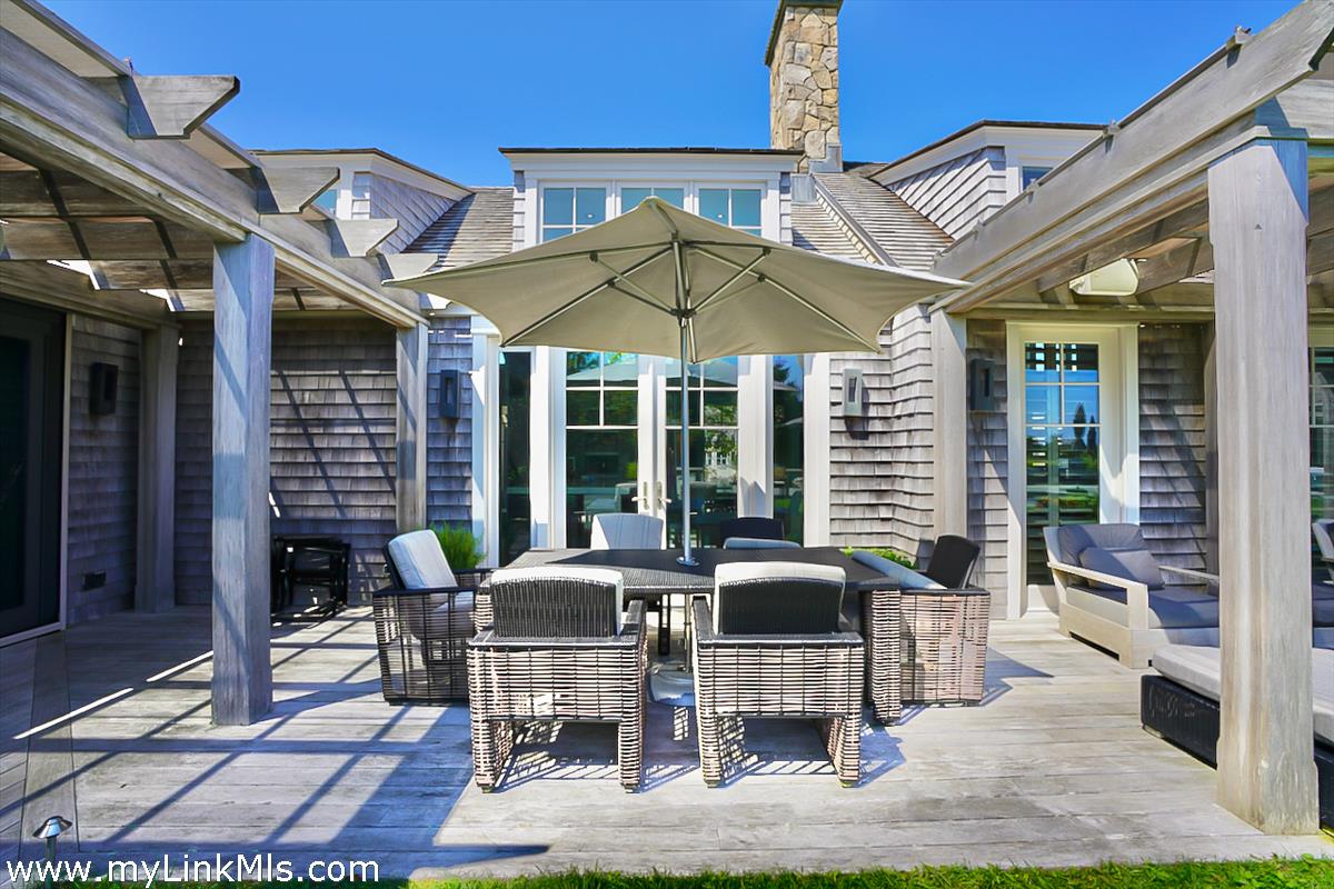 30 Crackatuxet Road Edgartown, MA 02539 - Photo 40 of 45 a view of the patio with dining table and chairs under an umbrella