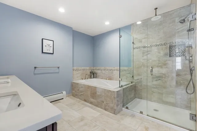 a spacious bathroom with a double vanity sink a mirror and a bathtub