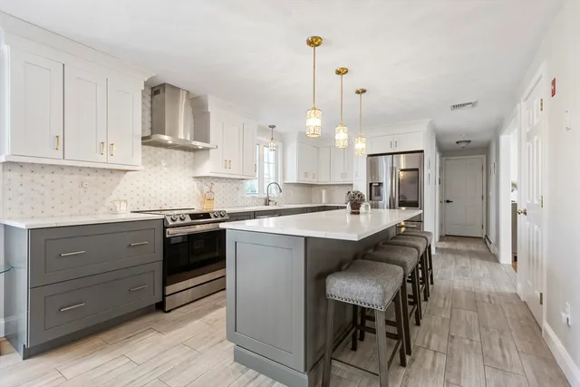 a kitchen with a table chairs refrigerator and cabinets