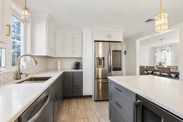 a kitchen with a sink cabinets stainless steel appliances and a window