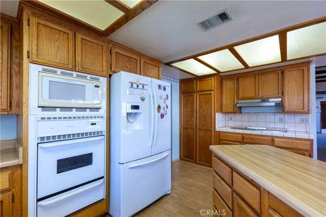 a kitchen with stainless steel appliances granite countertop a refrigerator and a stove
