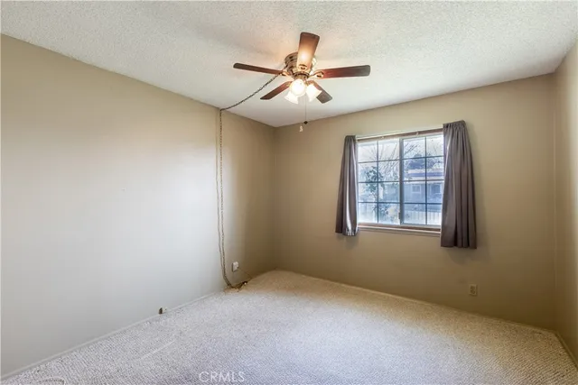 an empty room with windows and fan