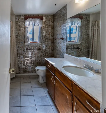 a spacious bathroom with a granite countertop sink toilet and mirror