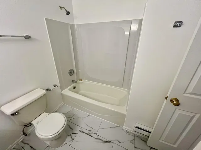 a bathroom with a granite countertop sink mirror vanity and toilet