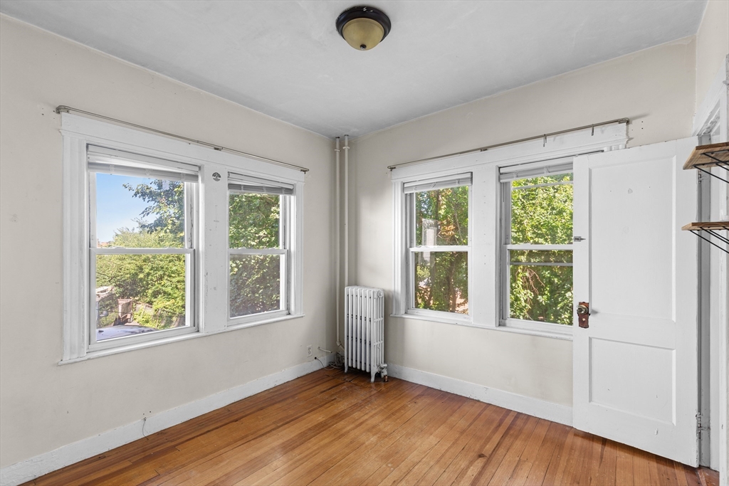 227 Winchester Street, Unit A Brookline, MA 02446 - Photo 12 of 18 a view of an empty room with wooden floor and a window