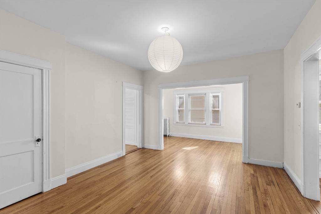 227 Winchester Street, Unit A Brookline, MA 02446 - Photo 3 of 18 a view of an empty room with wooden floor and a window
