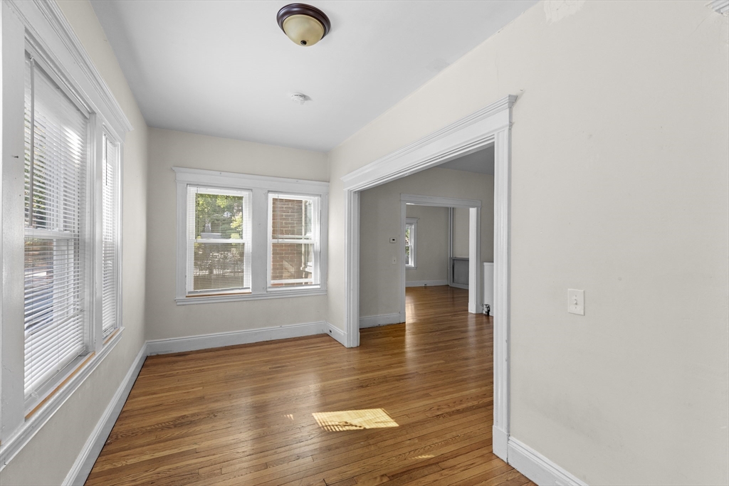227 Winchester Street, Unit A Brookline, MA 02446 - Photo 4 of 18 a view of an empty room with wooden floor and a window