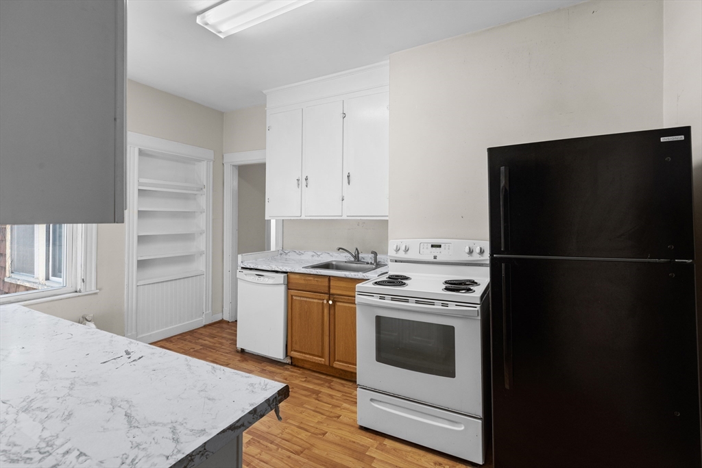 227 Winchester Street, Unit A Brookline, MA 02446 - Photo 6 of 18 a kitchen with a stove refrigerator and microwave